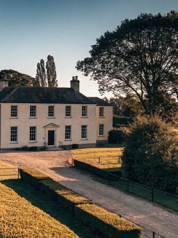 Cream Georgian detached house with a gravel drive